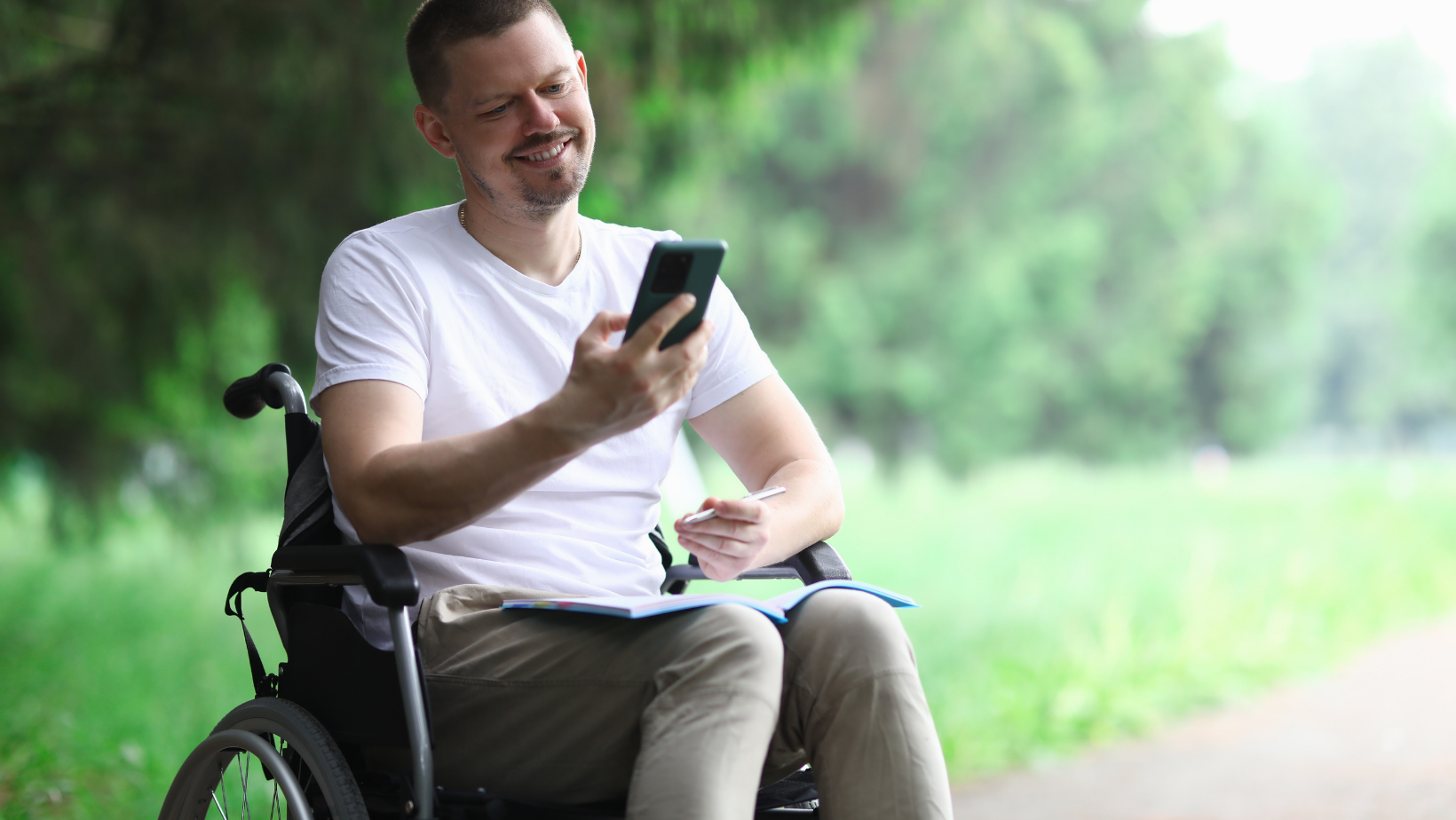 Young man in a wheel chair looking at phone